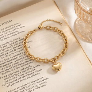 14K gold plated chunky chain bracelet with puffy heart charm displayed on open poetry book, water resistant gold bracelet by Caeli Jewelry