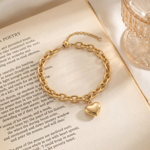 14K gold vermeil chunky chain bracelet with puffy heart charm displayed on open poetry book, water-resistant gold bracelet by Caeli Jewelry
